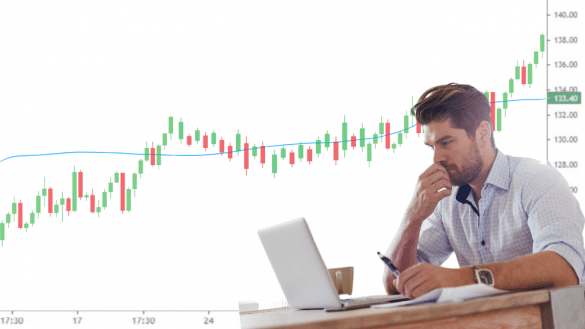 A person working on a computer and analyzing stock market data.