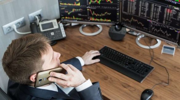 a man facing the computer with trading chart